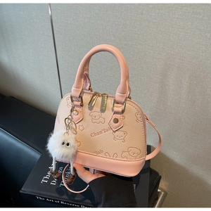 Pink lychee leather shell bag with cute puppy print and fluffy eye pompom charm