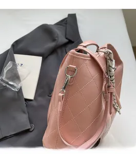 Détail du sac seau rose matelassé avec ferrures argentées et bandoulière tressée