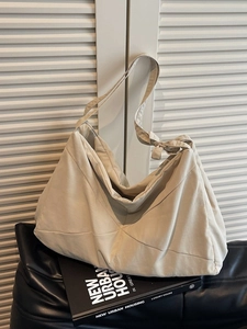 Minimalist beige quilted tote bag with wide bow shoulder strap for daily commuting
