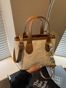 Chic beige and brown leather bucket bag with star embossing and crossbody strap