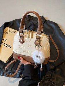 Chic cream and brown shell-shaped crossbody bag with cute animal embossing and fur charm