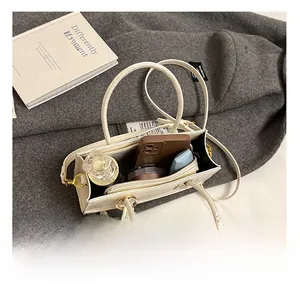 Innenansicht einer kleinen weißen Umhängetasche mit Platz für Handy und Parfüm