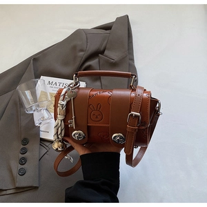 Close-up of brown retro handbag with animal embossing and silk scarf accessory