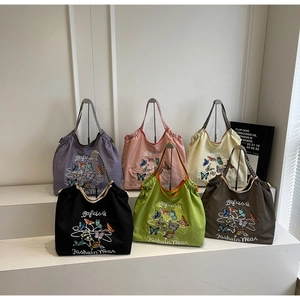 Détails de plusieurs sacs cabas en toile colorés avec broderie papillon élégante