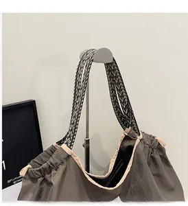 Détail d'un sac cabas en toile avec bandoulière tissée colorée et liseré beige renforcé