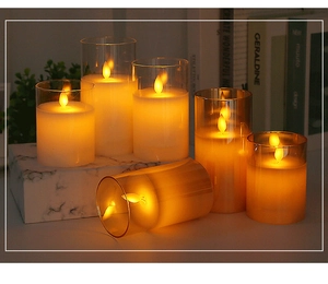 Dettaglio di candele LED in vetro ambrato con effetto fiamma oscillante e luce calda