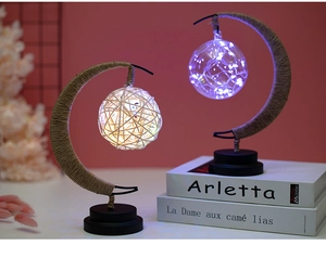 Detail of moon-shaped LED night light with warm rattan ball and cool blue glass bulb