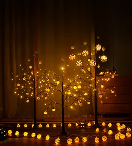 Illuminated Halloween ghost tree set with warm pumpkin lights and spider decorations