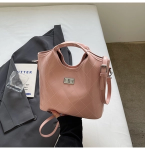 Détail d'un sac à main matelassé rose clair avec fermoir rotatif et bandoulière réglable