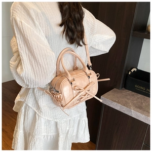 Détail du mini sac Boston rose avec nœud et bandoulière réglable sur le mannequin