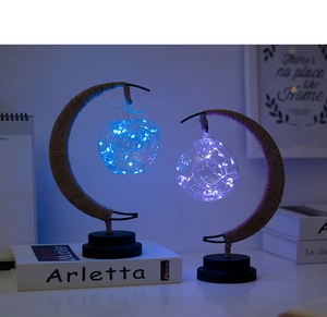 Detail of moon-shaped LED lamps with hemp rope and hanging glass glowing in blue and purple