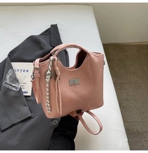 Détail du sac à bandoulière rose matelassé avec fermoir rotatif argenté et breloque