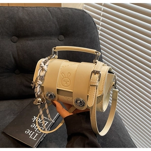 Detailed view of beige cream pillow bag with rabbit embossing and silver metal lock