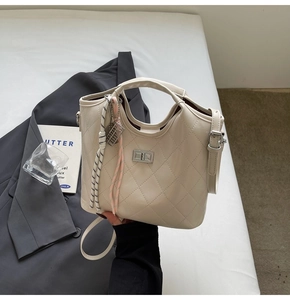 Détail du sac matelassé crème avec fermoir rotatif argenté et pendentif en corde