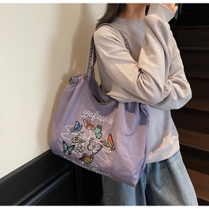 Détail du grand sac cabas violet avec broderie papillon et bandoulière à carreaux
