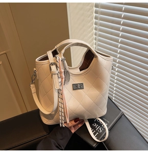 Détail du sac à main matelassé crème avec fermoir rotatif argenté et gland de corde