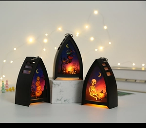 Three gothic Halloween lanterns with pumpkin and witch motifs on warm LED backlights
