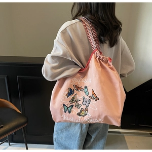 Sac fourre-tout rose à cordon avec motifs papillons et bandoulières tissées