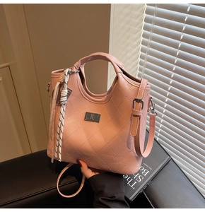 Détail du sac à main en cuir matelassé rose avec boucle argentée et cordon tressé