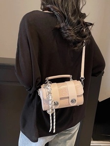Pink crossbody pillow bag with cartoon embossing and decorative woven knot charm