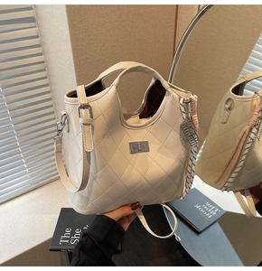 Détail du sac à main beige matelassé avec fermoir rotatif et pendentif en corde