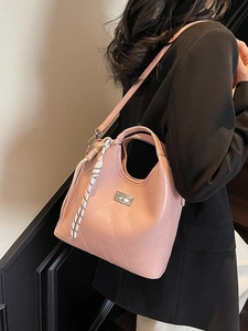Sac à main matelassé rose avec fermoir rotatif argenté et bandoulière sur modèle
