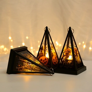 Close-up of pyramid Halloween lanterns with skull and witch patterns in warm LED light
