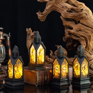 Set van vier Halloween lantaarns met LED gloeiende pompoen en kasteel op vintage boeken