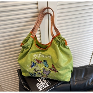 Détail du grand sac cabas en toile vert clair avec broderie de papillon colorée