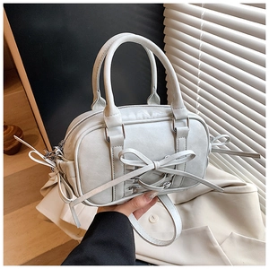 Détail d'un sac Boston élégant avec nœud décoratif et texture en similicuir souple