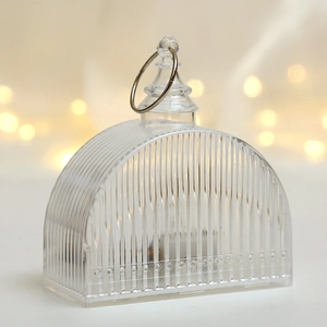Detail of transparent fluted LED candle light with metal hanging ring and warm bokeh light