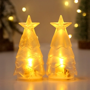 Nahaufnahme der warmen LED-Weihnachtsbaumkerzen mit Glitzer und Sternenaufsatz