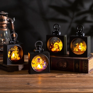 Close-up of Halloween LED lanterns with pumpkin and witch silhouettes on a wooden table