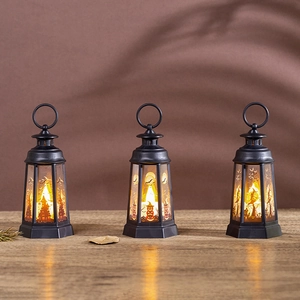 Three vintage Halloween LED lanterns with pumpkin and witch patterns on a wood table