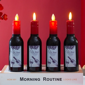Set of 4 wine bottle LED electronic candles with flickering warm flames on red background