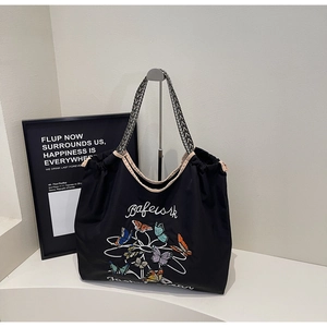 Détail du grand sac cabas noir avec imprimé papillons et anses tissées noir et blanc