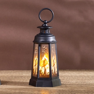 Detail of Halloween LED lantern with witch and bat silhouettes on a wooden table