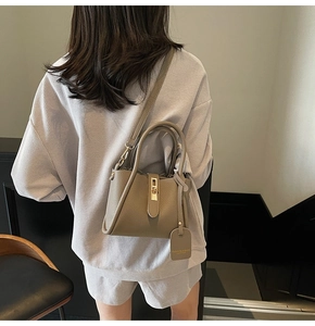 Close-up of earth-toned leather bucket bag with gold clasp and textured grain finish