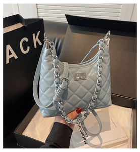 Détail du sac à bandoulière matelassé bleu clair avec fermoir rotatif en métal argenté