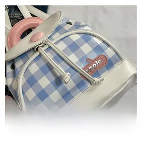 Macro shot of blue and white checkered backpack with apple patch and pink handle