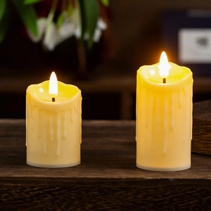 Detail of two LED flameless candles with realistic dripping wax on wooden surface