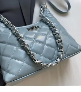 Detail of light blue quilted chain bag with silver buckle and glossy leather texture
