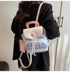 Detail view of mini backpack in blue checkerboard pattern with pink card holder accessory