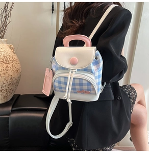 Mini backpack in blue plaid with pink accents shown with a model for travel and casual use