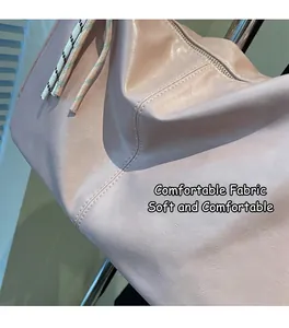 Detailed macro view showing soft pink leather texture and fine stitching of the shoulder bag
