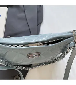 Detail of silver metal zipper and clasp on light blue quilted leather handbag