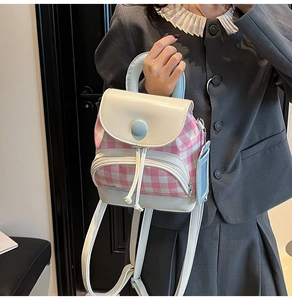 Detailed view of mini plaid backpack with blue handle and hanging card holder accessory