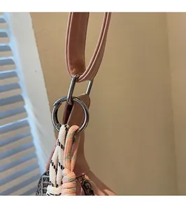 Detail of pink shoulder bag showing silver ring hardware and woven cord accents