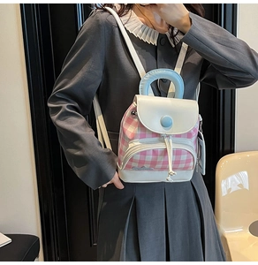 Detail of mini plaid backpack with pink and white pattern and light blue top handle