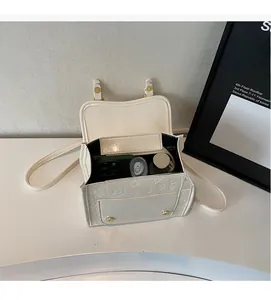 Détail du compartiment intérieur spacieux de ce sac bandoulière vintage en similicuir crème